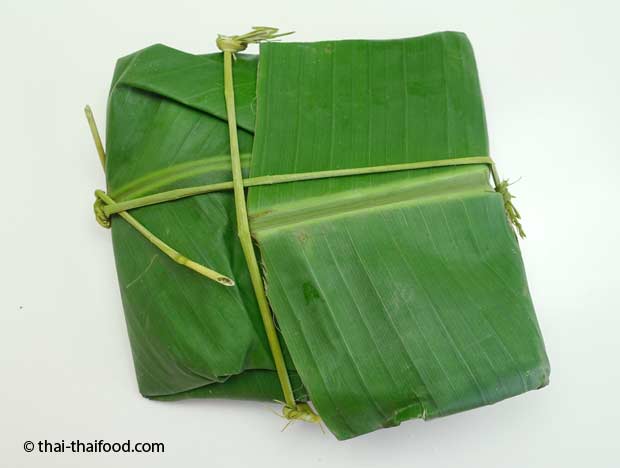 grüner Reis verpackt in Bananenblätter