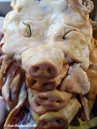 Gestapelte Schweinemasken auf dem Talat Thai Markt