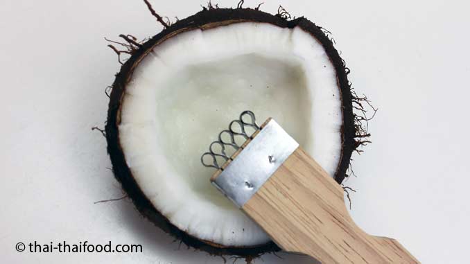 Kokosnussraspler mit geöffneter Kokosnuss